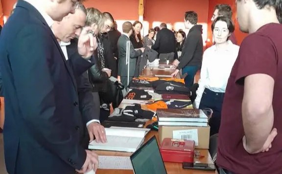 Etudiants dans une salle avec des t-shirts sur des tables