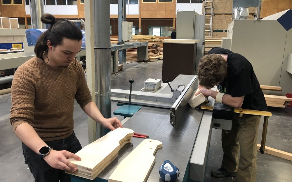 Etudiants travaillant sur de l'ameublement bois avec une machine de la halle