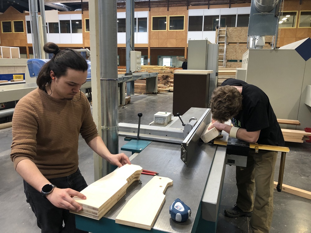 Etudiants travaillant sur de l'ameublement bois avec une machine de la halle